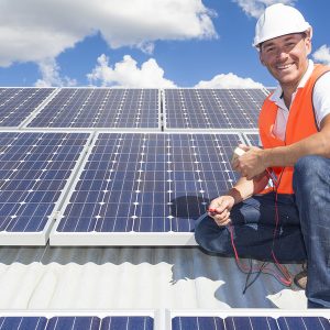 Solar panel technician on roof with solar panels